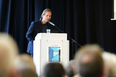 Marko Neumann am Pult Marko Neumann steht an einem Pult und hält einen Vortrag bei der Schulleitungsveranstaltung